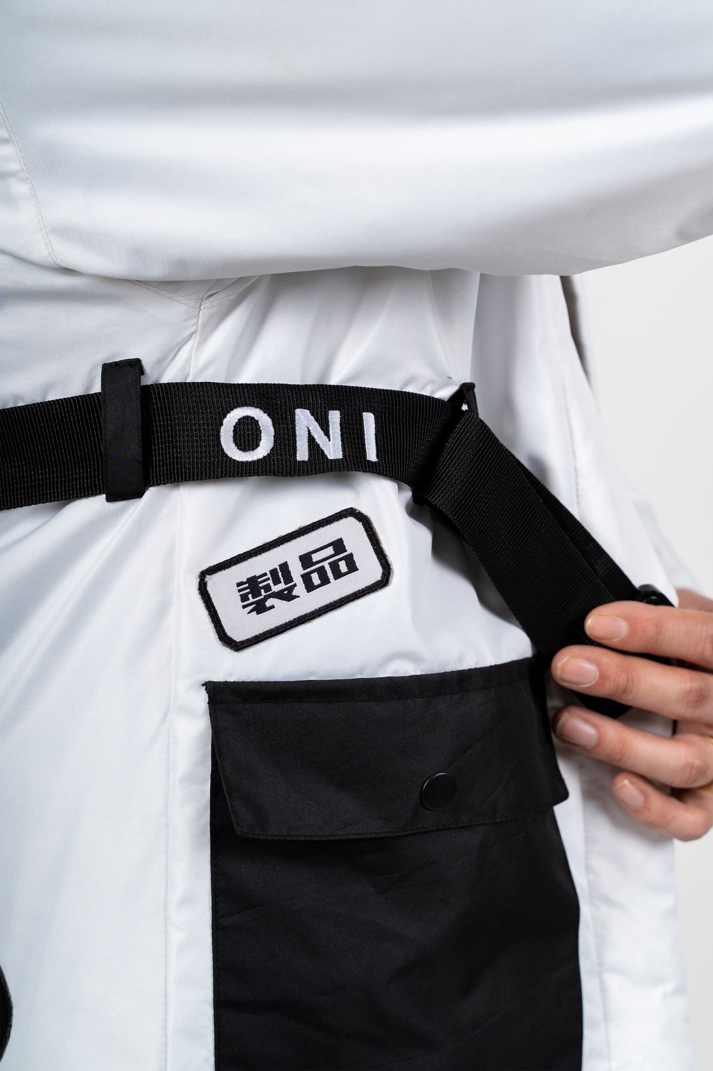 Zoom sur broderie Oni noire du kimono techwear Gin blanc